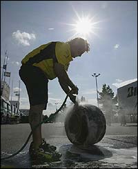 A mechanic washes a tyre during qualifying for the French Grand Prix 