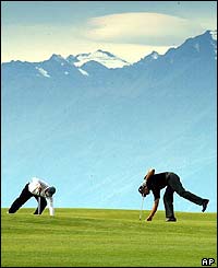 Paul Eales from Great Britain and Henrik Bjornstad from Norway pick up their golf balls next to the seventh hole during the European Masters in Switzerland