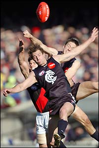 Carlton Blues' Simon Beaumont gets in front of Essendon Bombers' Matt Lloyd during the AFL match at the MCG