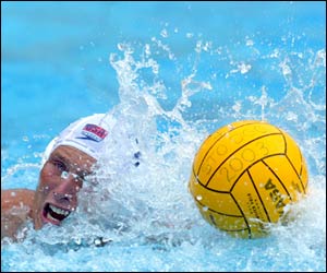 American Jesse Smith pushes the ball up the pool against Canada during the men's water polo competition 