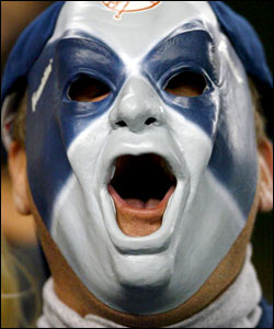 A New York Yankees fan wearing a mask cheers his team on against the Boston Red Sox during game seven of the American League Championship Series