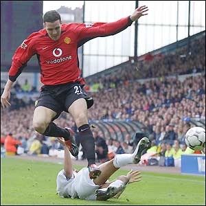 John O'Shea hurdles Leeds striker Alan Smith