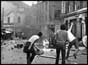 Rioters throwing missiles at armoured police car