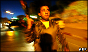 A Palestinian policeman outside the government building after it was set on fire in 2006 during Palestinian factional rivalry