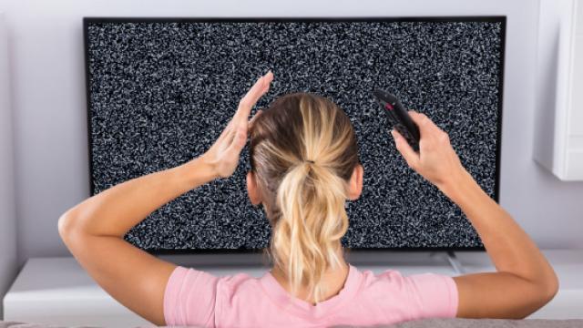 Image showing fuzzy screen with a frustrated lady holding a remote control 