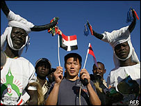 Một người Trung Quốc với những người Sudan trong trang phục truyền thống