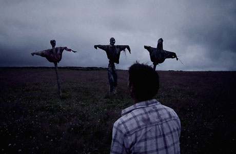 As Sean (Joseph Millson) flees the vengeful Bill Parry (Josh Richards) he chances across three scarecrows, mistaking them in the dim light for help. Photo © Dogs Of Annwn Ltd.