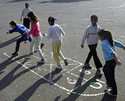 Children playing hopscotch in playground