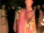 Clergyman lighting the Paschal candle from a taper