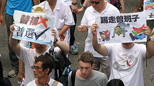 香港市民在参与七一游行时高举要求撤回立法会依稀递补机制和曾荫权下台的标语牌(1/7/2011)
