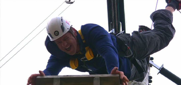 Steve Backshall doing a handstand on top of a tall pole