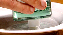 Yan holds a glass over a cube of sugar