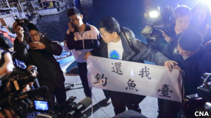 台湾保钓人士在新北市深澳港出发前向记者展示标语(台湾中央社图片24/1/2013)