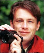 Chris Packham with a pair of binoculars