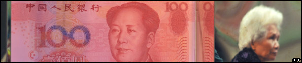 A pedestrian is reflected in the walls of a business decorated with replica Chinese 100-yuan notes featuring a portrait of late Chinese leader Mao Zedong in Hong Kong on March 1, 2009