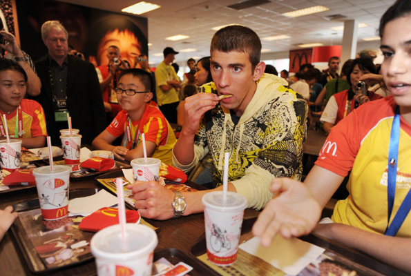 Olympic swimmer Michael Phelps, takes lunch with children as he visits a US fast food chain restaurant in the Olympic Green in Beijing in 2008.