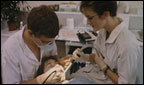 A dentist works on a young child