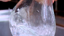 An empty glass bottle is filled and empty of hot water