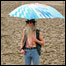 Homem se protege da chuva no festival de Glastonbury