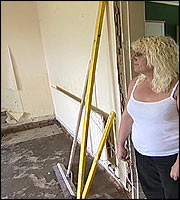 A resident inspects damage at her home 