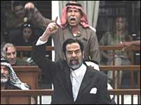 صدام حسين هنگام دادن شعار در دادگاه