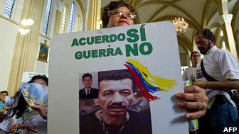 A relative of FARC hostage Jorge Humberto Romero holds a poster with his picture on it, during a mass at the cathedral of Villavicencio on April 1, 2012.