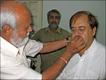 L.L. Chinyara sticking the Charlie moustache on Ashok Aswani 