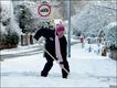 一名妇女在路边铲雪