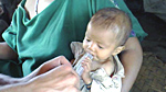 Chris, the team doctor, diagnoses and treats a baby in the Ashaninka village near Catunga.