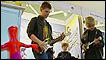 Crianças brincam com guitarra de brinquedo em feira de Londres