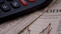 Calculator and financial pages of a newspaper