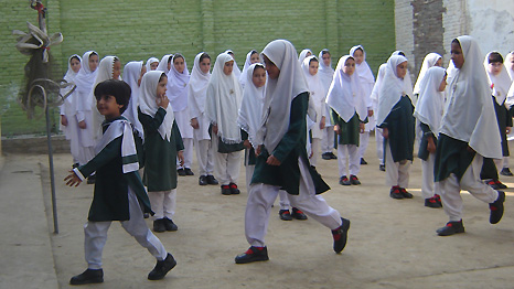 Children smiling and marching into school