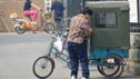 A woman with her bike and trailer.