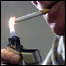 Homem acende um cigarro