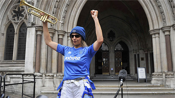 A Portsmouth fan celebrates outside the High Court