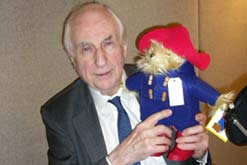 Michael Bond holding a Paddington Bear toy
