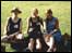 Three women sitting on grass