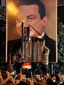 Photo shows protestors tearing down a poster 