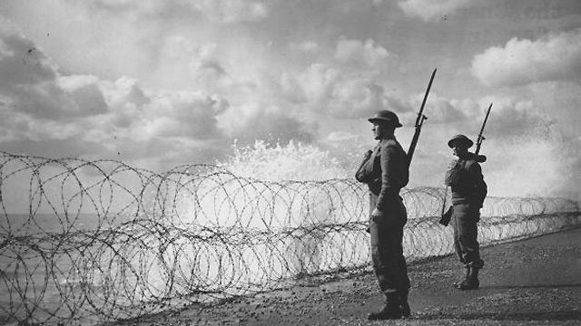 Armed soldiers stand guard on a south coast beach, 2 September 1940.