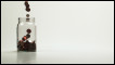 Coins tumbling into a glass jar