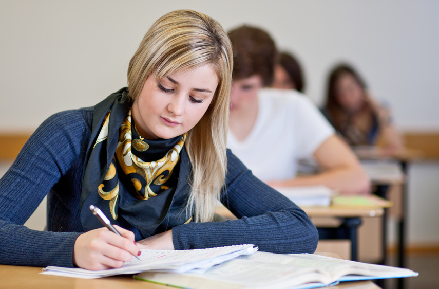 Student working on homework in classroom @ Moritz Wussow Fotolia.com