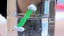 The straw with sticky-tack stays still in the middle of the water