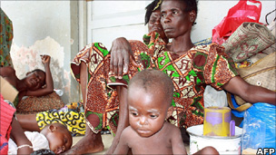 Ivorian mothers and children sit at a UNHCR camp for displaced people in Duekoue.